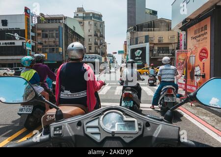 Piloti su scooters attendere a un incrocio in una giornata calda in Tainan, Taiwan. Visto da un compagno di rider del punto di vista Foto Stock