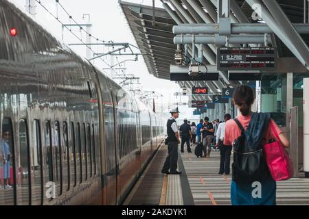 I passeggeri in attesa su piattaforma come Taiwan high speed rail bullet train arriva a Tainan HSR stazione, Taiwan Foto Stock