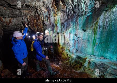 28 novembre 2019, Sassonia-Anhalt, Sangerhausen: Thomas Wäsche (secondo da destra), guida del tour spiega a un gruppo in un'escursione attraverso il reed Wettelrode albero nel cosiddetto 'Green Vault' come la sinterizzazione sulle pareti di galleria si verifica. Poiché l'albero è stato abbandonato nel 1885, permanentemente acqua fluente ha minerali sciolti dal calcare, che forma una crosta sulle pareti. La tavolozza dei colori varia da forti tonalità marrone al bianco, verde turchese blu e nero. Per circa venti anni il museo "ErlebnisZentrum Bergbau Röhrigschacht Wettelrode' è stata offerta di escursioni più unde Foto Stock