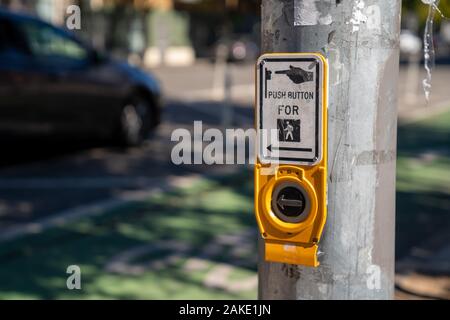 Premere il pulsante attraversare a piedi intersezione sulla luce post con segno Foto Stock