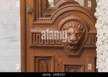 Grande testa di legno di Lion su porta anteriore. Foto Stock