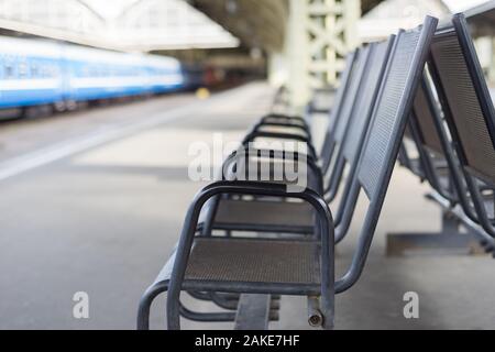 Immagine sfocata della sedia in attesa nella zona della stazione ferroviaria Foto Stock