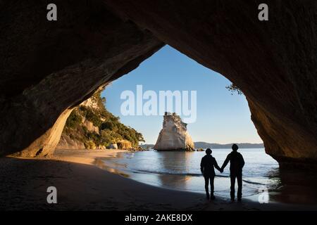 Due persone godendo la vista del Cove della cattedrale di sunrise, Coromandel, Isola del nord, Nuova Zelanda Foto Stock