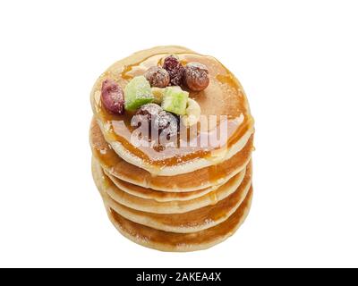 Pila di frittelle calde con noci, frutta secca e sciroppo di caramello. Isolato Foto Stock