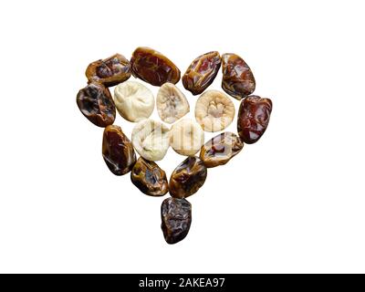 Assortimento di fichi secchi e di date in forma di cuore isolato su sfondo bianco. Foto Stock