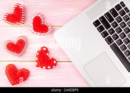 Valentines lo sfondo del desktop con Rosso cucito a mano cuore dono e il computer portatile Foto Stock