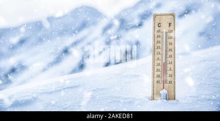 Termometro sulle montagne nella neve mostra temperature sotto zero. Basse temperature in gradi Celsius e Fahrenheit in caso di neve Foto Stock