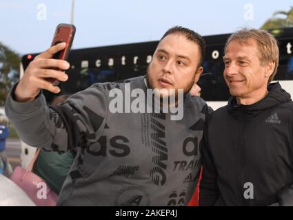 08 gennaio 2020, US, San Pietroburgo: Calcio: Test match, Hertha BSC - Eintracht Frankfurt Al Lang Stadium. Hertha coach Jürgen Klinsmann (r) è avente la sua immagine scattata con una ventola per un selfie. Foto: Nigel Worrall/dpa Foto Stock