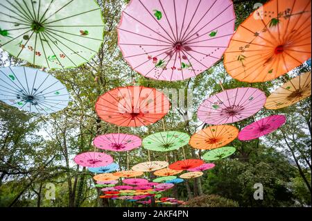 Cinese tradizionale ombrelloni multicolori impiccati sugli alberi a basso angolo di visione in Guilin, provincia di Guangxi, Cina Foto Stock