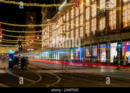 Amsterdam, Paesi Bassi 23 dicembre 2019 : Lungo la luce di esposizione davanti a De Bijenkorf shopping mall di notte su piazza Dam in Amsterdam Foto Stock
