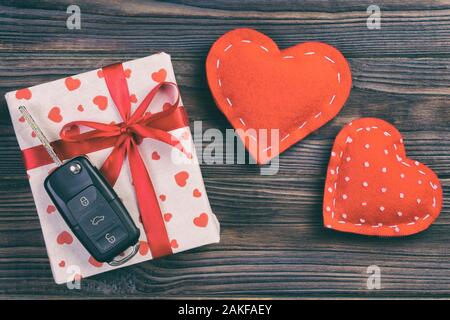 Valentino o altre vacanze presente fatti a mano in carta con cuori rossi, chiavi auto e regali box in involucro di vacanza. scatola regalo in tavola Farkwooden vista superiore Foto Stock