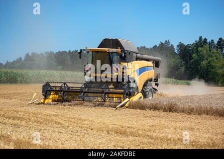 Macchina mietitrebbiatrice è il raccolto di un campo di grano Foto Stock