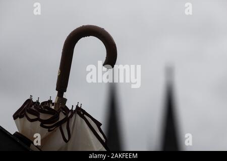 Colonia, Germania. 9 Gen, 2020. C'è un ombrello bloccato in un cestino della spazzatura. Sullo sfondo si possono vedere le cime della cattedrale. Credito: Rolf Vennenbernd/dpa/Alamy Live News Foto Stock