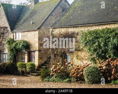 Un paio di graziosi cottage in pietra nel villaggio Costwold di Hampnet nel Gloucestershire. Foto Stock