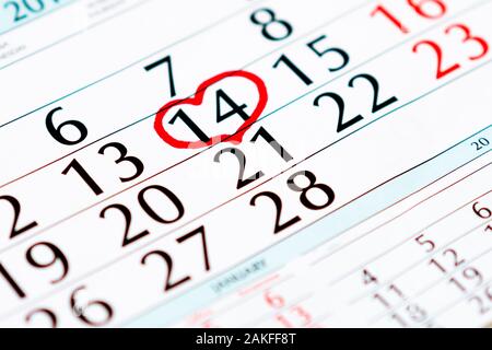 Cuore rosso sul calendario con segnata la data del giorno di San Valentino, primo piano calendario pagina con il cuore rosso il 14 febbraio Foto Stock