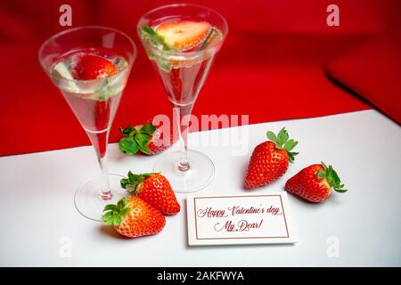 Due bicchieri di champagne con fragole e buon San Valentino card . Foto Stock