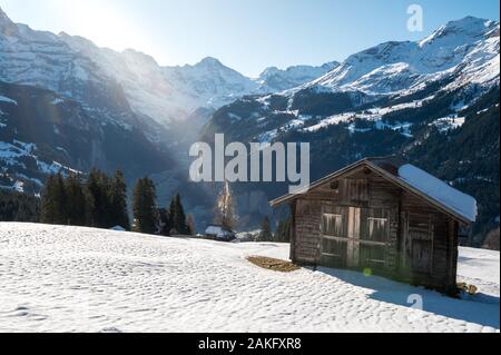 Magica Valle di Lauterbrunnen visto da di Wengen con fienile su una coperta di neve campo Foto Stock