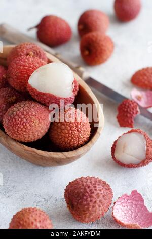 Litchi freschi frutti in un recipiente in un tavolo bianco close up Foto Stock