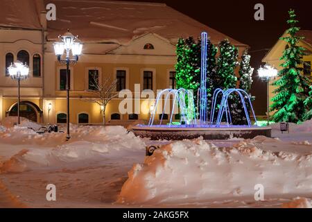 Garland fontana nel Winter Park di notte con decorazioni, luci e alberi. Foto Stock