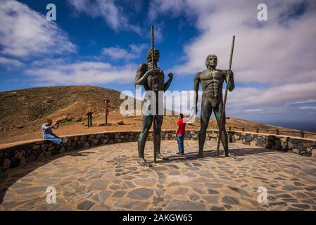 Spagna Isole Canarie Fuerteventura Island, Betancuria, Mirador de Morro Velosa, staues che rappresenta il pre-Spagnolo Guanche kings, Ayoze e Guize, con visitatori Foto Stock