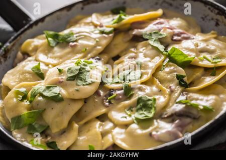 Ravioli di pasta ripieni di spinaci mustooms prosciutto basilico e parmigiano Foto Stock