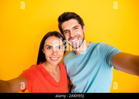 Foto di due funny guy lady gente giovane rendendo carino selfies registrazione video per nuovi social network blog indossare casual blue t-shirt arancione isolato Foto Stock