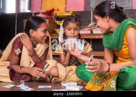 Didascalia: After-School Club (ASC) Coordinatore Asha, che lei stessa ha la scoliosi, porta i bambini in un gioco di carte. Il gioco è molto visivo, progettato per essere io Foto Stock