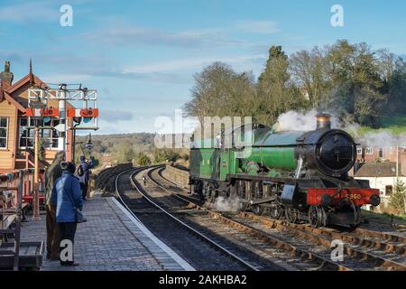 La locomotiva a vapore d'epoca britannica Raveningham Hall sulla linea storica della Severn Valley Railway, che arriva alla stazione di Bewdley sotto il sole invernale. Foto Stock