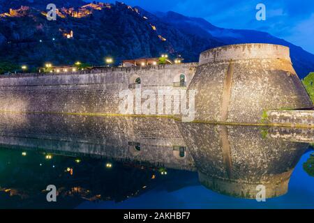 Città i bastioni della città vecchia che riflette in acqua al tramonto, Sito Patrimonio Mondiale dell'Unesco, Kotor, Montenegro Foto Stock