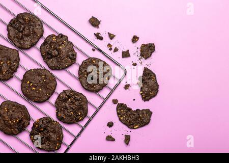 In casa senza glutine biscotti con scaglie di cioccolato con cereali, noci e cacao organico. Biscotti e pasticcini da farina di segale su uno sfondo colorato. Il glutine Foto Stock