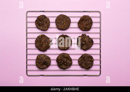 In casa senza glutine biscotti con scaglie di cioccolato con cereali, noci e cacao organico. Biscotti e pasticcini da farina di segale su uno sfondo colorato. Il glutine Foto Stock