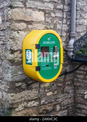 Un moderno pubblico accesso defibrillatore fissato ad una parete di pietra. Foto Stock