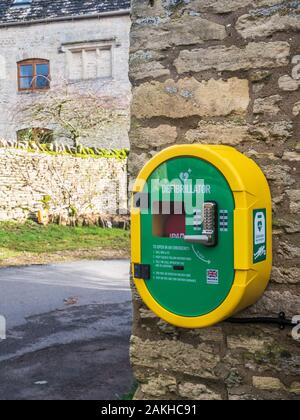 Un moderno pubblico accesso defibrillatore fissato ad una parete di pietra. Foto Stock