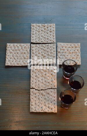 La cena del Signore con pane a forma di croce e tre piccole tazze di vino Foto Stock