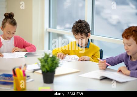 Tre ragazzi studiano presso la classe insieme Foto Stock