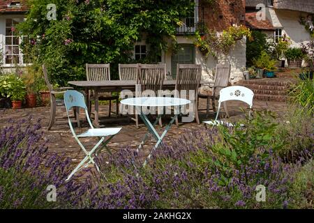 Mobili da giardino in metallo sul patio in pietra nel giardino estivo inglese Foto Stock