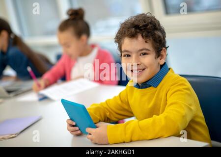 Allievo di essere felice con i moderni dispositivi a scuola Foto Stock