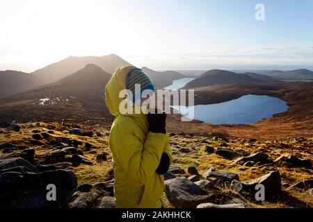 Mourne Montagne e laghi in Irlanda del Nord, Regno Unito. Vista da Slieve Loughshannagh, ritratto di un ragazzo sulla cima della montagna vista Foto Stock
