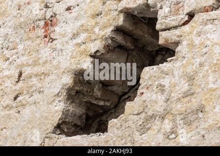 Foro in un vecchio muro di pietra di una rovina Foto Stock