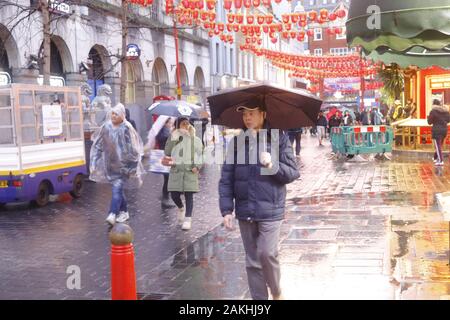 Londra, regno unito, 9 gennaio 2020. Meteo Regno Unito. Piove a Chinatown, la gente si ripara dalla pioggia a Londra questo pomeriggio. Londra, Regno Unito. Crediti: Ed Brown/Alamy Live News Foto Stock