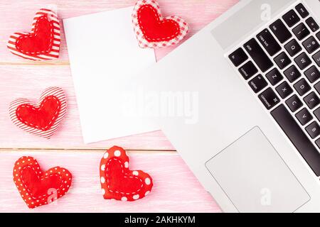 Valentines lo sfondo del desktop con Rosso cucito a mano cuore dono e il computer portatile Foto Stock