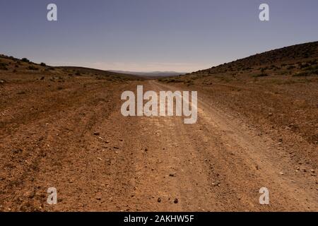 Una pista rettilinea per il sud nei pressi di sidi ifni, Marocco. la strada che conduce all'orizzonte. Foto Stock
