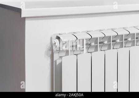 Bianco radiatore in alluminio sulla parete sotto plastica davanzale. Il design moderno. Decorazione della Casa. Foto Stock