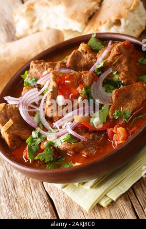 Il vitello chashushuli nel pomodoro piccante salsa di cipolla close-up in una ciotola sul piano verticale. Foto Stock