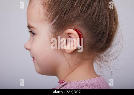 Apparecchi acustici nell'orecchio di Young Girl. Bambina che indossa un apparecchio  acustico. Scatto in studio Foto stock - Alamy