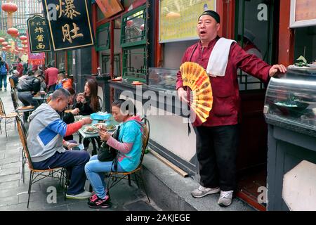 Donghuamen Street Restaurant & waiter - strada laterale fuori Wangfujing snack Street, Dongcheng District, Pechino, Cina Foto Stock