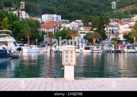 Prese elettriche bollard sul molo vicino alla costa del mare. Stazione di ricarica per barche e yacht nel Mediterraneo. Prese di corrente per caricare le navi in Foto Stock