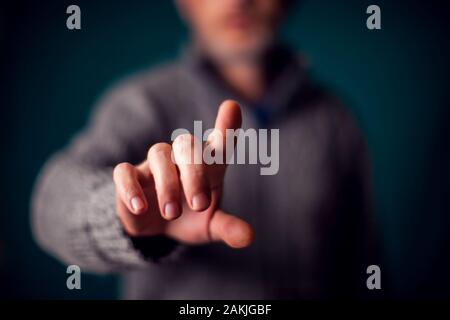Imprenditore nel soddisfare toccando il pulsante virtuale o rivolto a qualcosa di Foto Stock