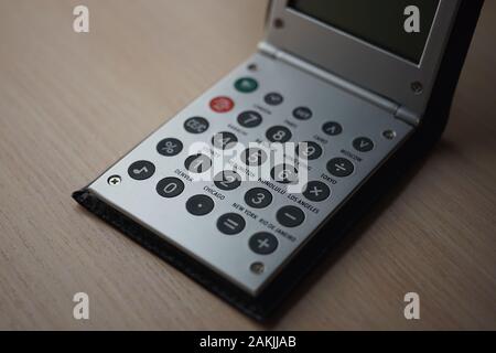 Metallo color argento calcolatrice pieghevole closeup su il marrone del tavolo di legno. Foto Stock