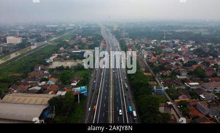 BEKASI, WESTJAVA, INDONESIA : 10 gennaio 2020 : antenna fuco vista autostrada multilevel junction road con vetture in movimento dopo piovosa. Le vetture sono sfocate Foto Stock
